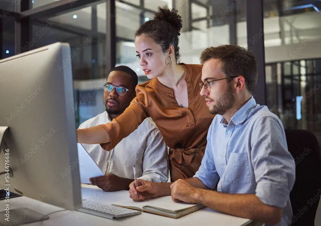 Colleagues reviewing market data on a desktop screen
